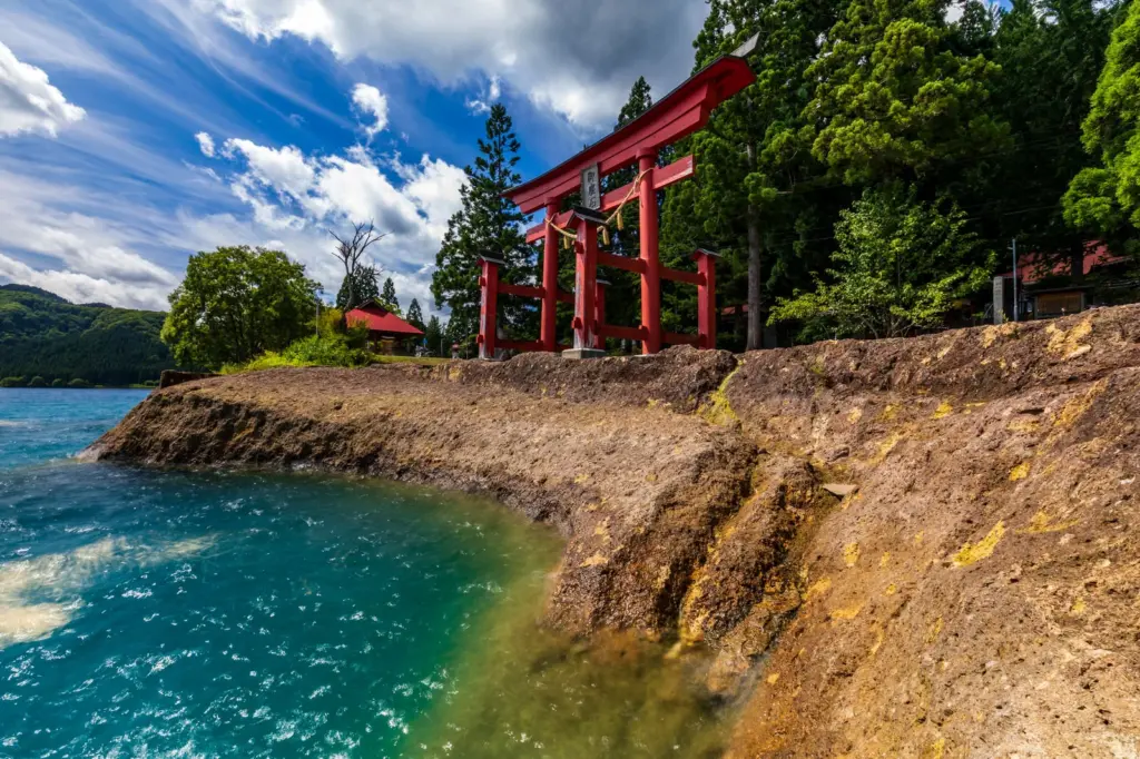 田沢湖の湖畔に立つ御座石神社（ござのいしじんじゃ）の朱色の鳥居。辰子姫伝説の龍神様を祀る水のパワースポット。